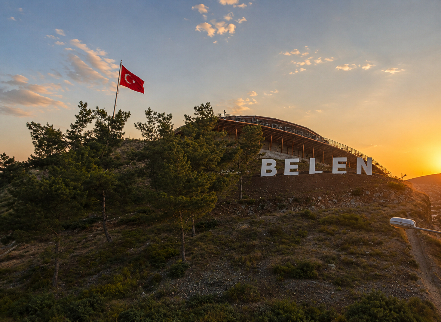 Belen tepesindeki dev BELEN yazısı, dalgalanan Türk bayrağı ve seyir terasının ahşap çatısı